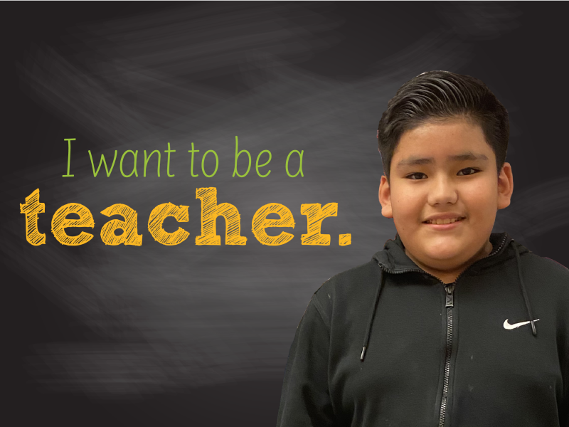 Three elementary aged boys looking at the camera with the one in the middle smiling big.